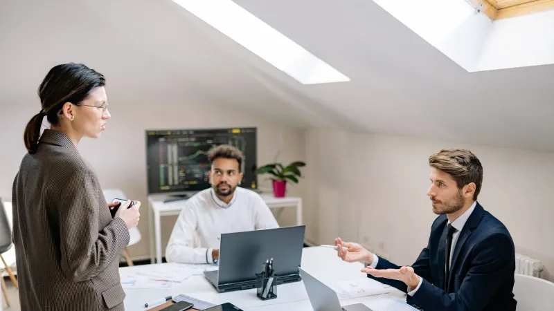Professionelles Meeting in einem hellen Büroraum mit vielfältigen Kollegen, die Ideen besprechen.