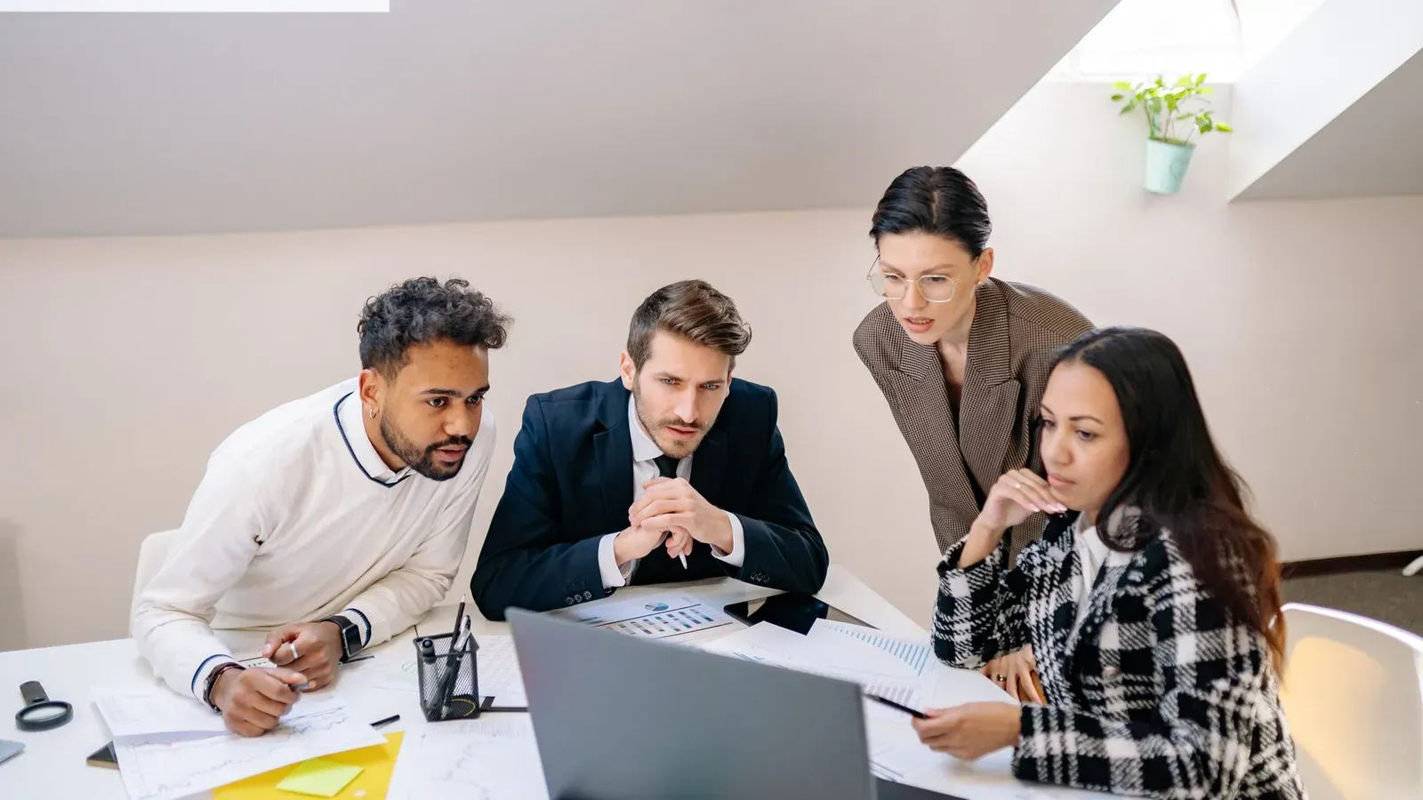 Ein vielfältiges Team von Fachleuten, das gemeinsam an einem Projekt in einer modernen Büroumgebung arbeitet.