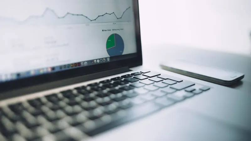 Ein Laptop, der ein Analyse-Dashboard mit Diagrammen und Grafiken zeigt und moderne Datenanalysetools symbolisiert.