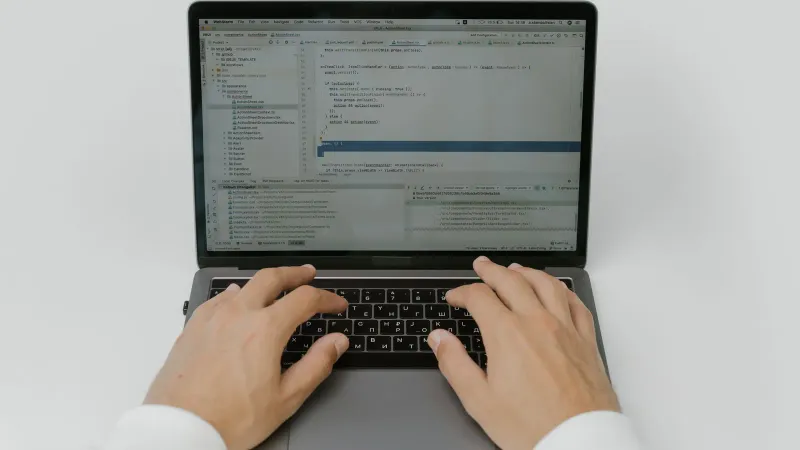 Nahaufnahme von Händen, die an einem Laptop codieren, zeigt die Softwareentwicklung in Aktion.