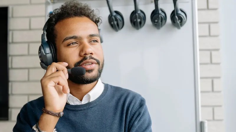 Ein Mann mit Headset, der in einem Callcenter arbeitet und aufmerksam nach vorne schaut.